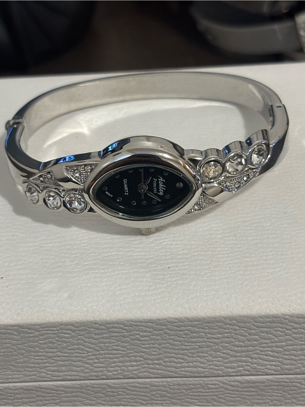Silver bangle watch with black face